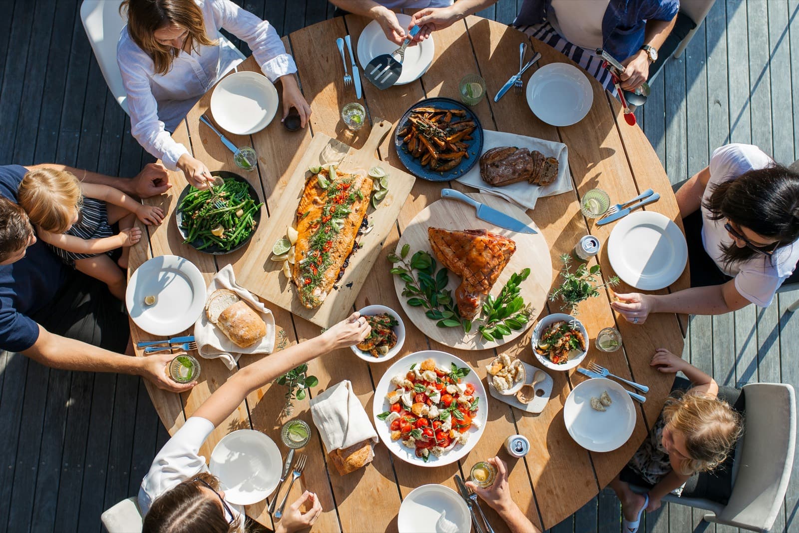 A long shared table seen from above, covered with family-style dishes